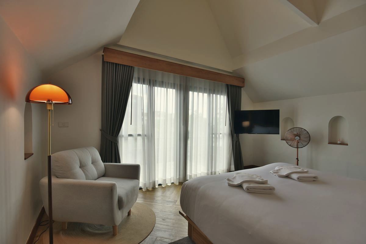 CHANS Suite under a pitched roof with armchair and arched niches