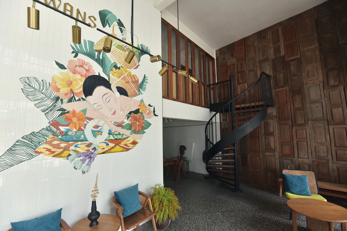 The Reception with mural, spiral stair and carved teak wall
