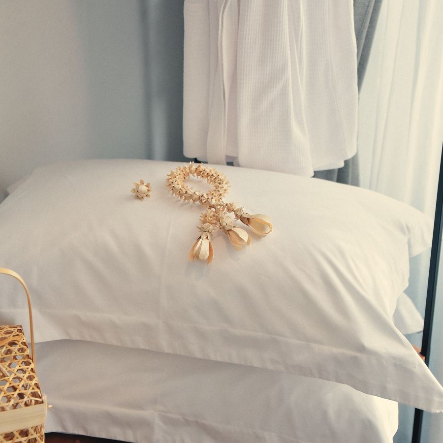 Stacked firm pillows in white cotton cases